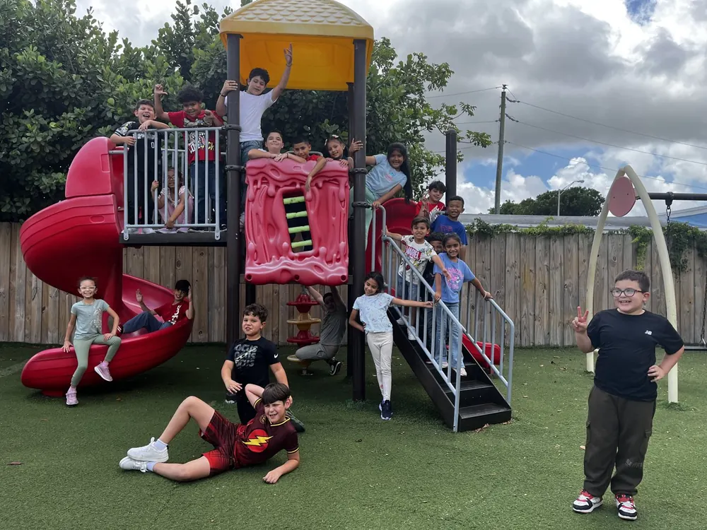 Niños posando y jugando en el área de juegos de la escuela