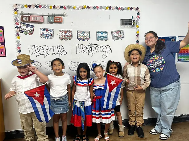 Niños con trajes típicos y banderas posan con su maestra frente a un mural de la herencia hispana