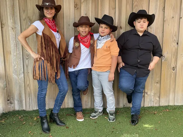 Una maestra y tres niños vestidos de vaqueros posan en el patio durante una celebración escolar